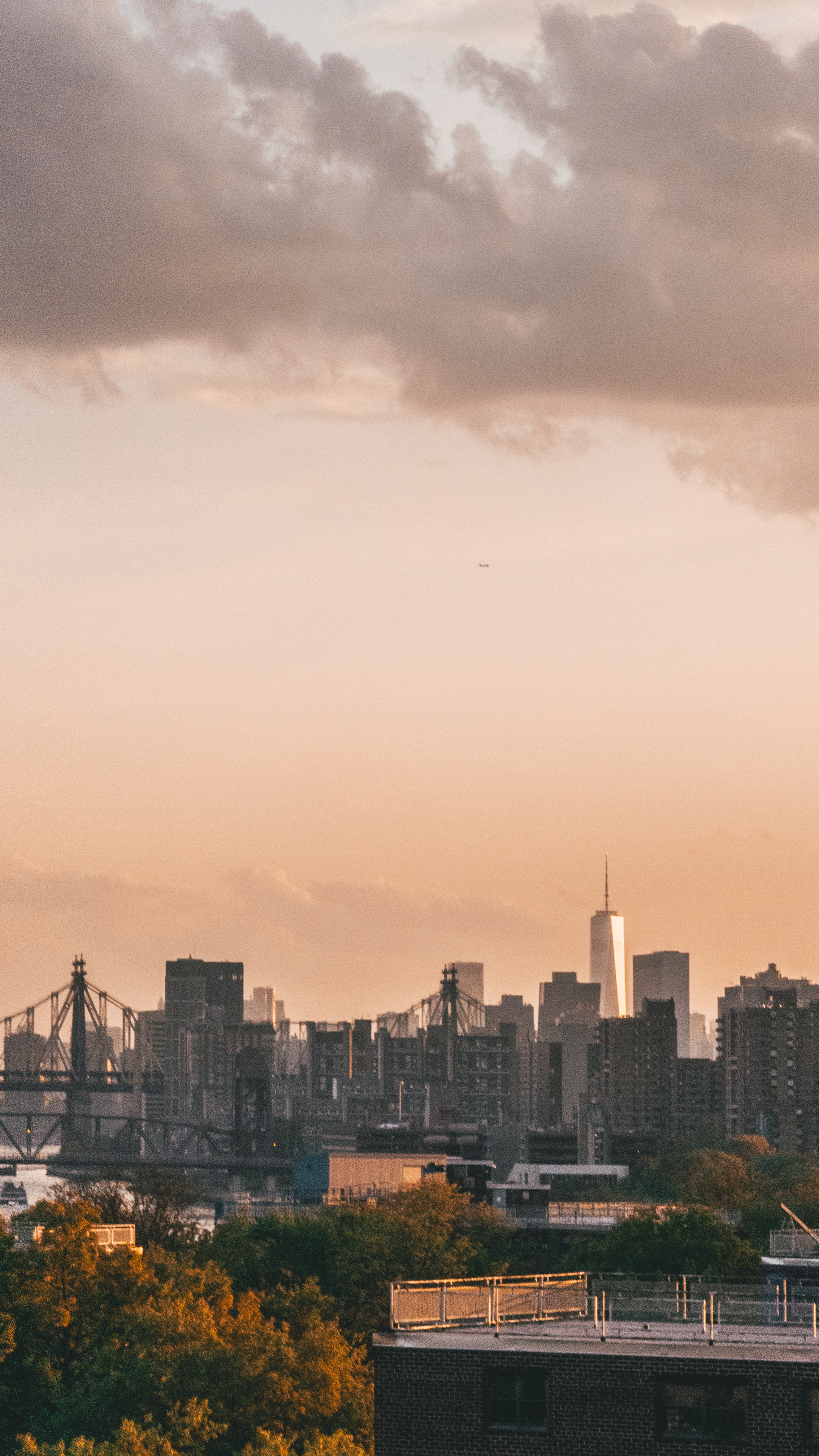 Skyline view of a city at sunset with bridges and skyscrapers under dramatic
clouds
